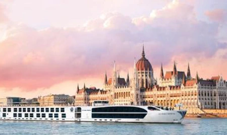 A river ship sailing beside Budapest's Parliament